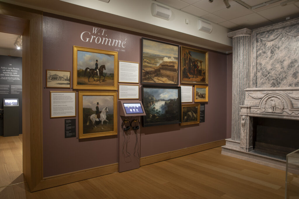 Kuva Pieni pala Pariisia -näyttelystä Grommen osuudesta. Koko seinä peitetty tauluripustuksella.